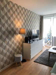a living room with a checkerboard patterned wall at Apartament Wejhera Gdańsk Żabianka blisko morza in Gdańsk