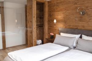 a bedroom with a bed with a wooden wall at Wellness Pension am Rain in Winden im Elztal