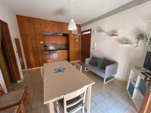 APPARTAMENTO ISIDE fronte spiaggia في فوساتشيزيا: مطبخ وغرفة معيشة مع طاولة وكراسي