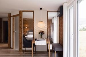 a bedroom with a bed and a table and a mirror at Wellness Pension am Rain in Winden im Elztal