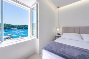 een slaapkamer met een bed en een groot raam bij La Porta 1, seaview apartment in the center in Cavtat