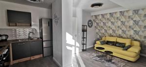 a living room with a yellow couch and a kitchen at Ferienwohnung Moselterrasse in Zell an der Mosel +10 photos