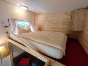 um quarto com uma cama num quarto de madeira em Alpenhotel Beslhof em Ramsau