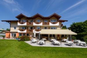 a large building with tables and chairs in a yard at Hotel Himmelreich in Wals