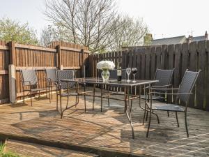 a patio with a table and chairs and a fence at Lilly May Cottage in Bridlington