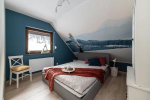a bedroom with a bed with a painting on the wall at Domek OlimpijSki SZCZYRK in Szczyrk