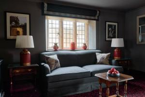 a living room with a blue couch and a window at The Lygon Arms - an Iconic Luxury Hotel in Broadway
