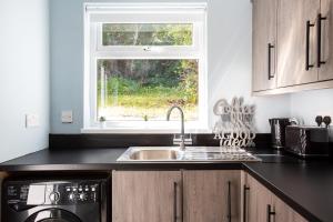 una cocina con fregadero y ventana en Fully refurbished North Belfast Home 3, en Belfast