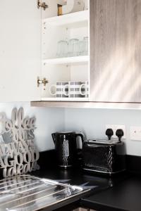 Una cocina con encimera y gabinetes negros. en Fully refurbished North Belfast Home 3, en Belfast 41 fotos más