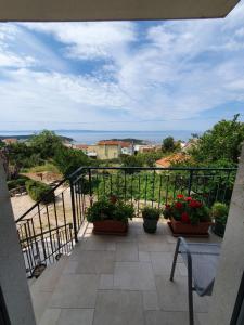a balcony with potted plants and a view of the ocean at Kuća za odmor Batinić in Makarska