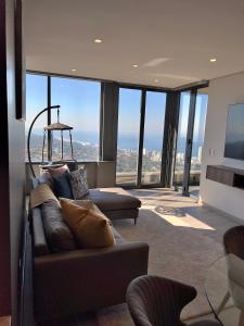 uma sala de estar com um sofá e janelas grandes em Umhlanga Arch Luxury em Durban