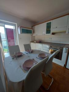 eine Küche mit einem Tisch mit Tellern und Weingläsern in der Unterkunft Apartment Hanna in Koper