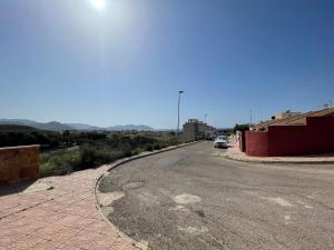 an empty road with a car parked on the side at El Alamillo ground floor apartment with sea view in Mazarrón