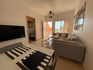 a living room with a couch and a table at El Alamillo ground floor apartment with sea view in Mazarrón