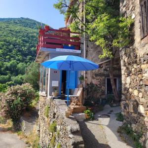 un paraguas azul sentado fuera de un edificio en Gîtes chez Daniel "Appartement Cevennes", en Mars