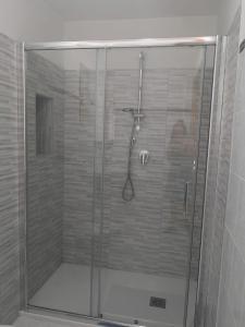 y baño con ducha y puerta de cristal. en Villa Donà Appartamento:Defensola, en Vieste