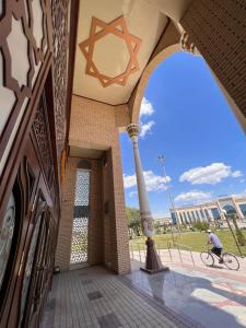 a person riding a bike in front of a building at Said Islom Khoja in Khiva