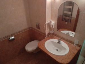 a bathroom with a sink and a toilet and a mirror at Апартамент Сънсет Ризорт in Pomorie +21 photos
