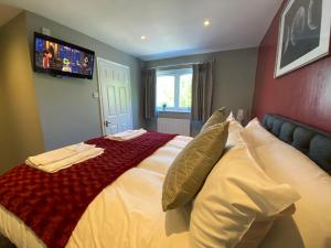 a bedroom with a large bed with a television on the wall at The Beeches, Ashby-de-la-Zouch in Ashby de la Zouch