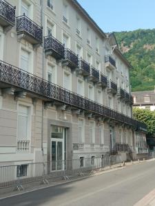 ein Gebäude mit Balkonen an der Straßenseite in der Unterkunft Appartement au coeur de Luchon in Luchon