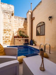 eine Terrasse mit einem Pool in einem Haus in der Unterkunft 250 yo Tal-Bambinu Farmhouse in Xagħra