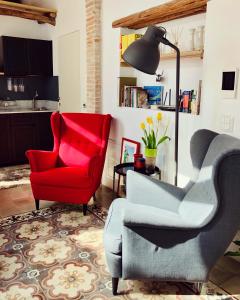 una sala de estar con 2 sillas y una silla roja en Su Zampillu Boutique Rooms Teulada, en Teulada