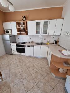 een keuken met witte kasten en een tegelvloer bij Apartments Lili in Biograd na Moru