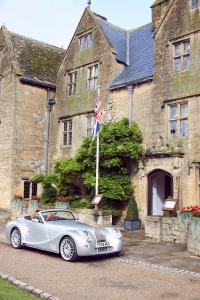 un coche plateado estacionado frente a un edificio en The Lygon Arms - an Iconic Luxury Hotel en Broadway