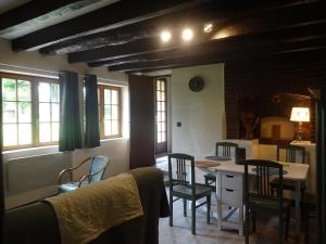 a kitchen with chairs and a table and a kitchen with a counter at Maison de campagne en Limousin in Dury