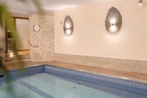 a swimming pool with two mirrors on the wall at Am Rain - Natur und Spa in Winden im Elztal +65 photos