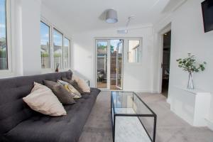 sala de estar con sofá y mesa de cristal en Ultimate Comfort 4-Bedroom Property for 7 People en Bromley