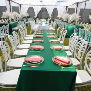 a long green table with white chairs and plates on it at PLUS 33 HOTEL in Nungua