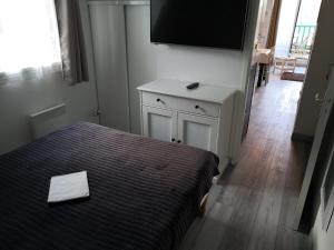 um quarto com uma cama e uma televisão de ecrã plano em Appartement fonctionnel et chaleureux proche mer em Le Croisic