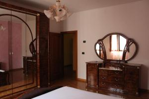 Zimmer mit Spiegel, Kommode und Lampe in der Unterkunft CASA VACANZE “ LA TERRAZZA “ in Comacchio