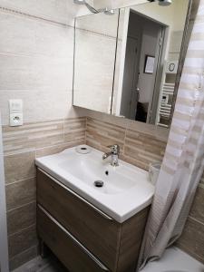 a bathroom with a sink and a mirror at Appartement fonctionnel et chaleureux proche mer in Le Croisic