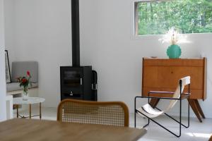 ein Wohnzimmer mit einem Tisch, Stühlen und einem TV in der Unterkunft Maison de vacances, proche Océan, idéal famille in Saint-Vivien-de-Médoc