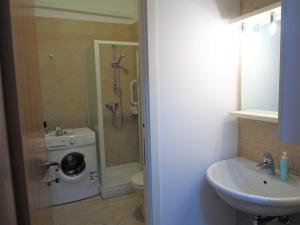 a bathroom with a sink and a washing machine at La Vigna Del Parroco in Verduno