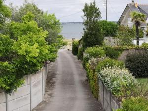 una strada sterrata con cespugli e alberi laterali di Appartement fonctionnel et chaleureux proche mer a Le Croisic