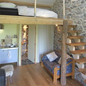 a bedroom with a bunk bed and a couch in a room at le Henry in Queyrières