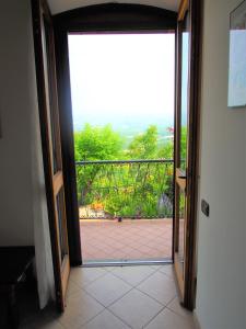 an open door to a balcony with a view at La Vigna Del Parroco in Verduno