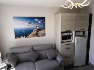 a living room with a couch and a kitchen at Appartement fonctionnel et chaleureux proche mer in Le Croisic