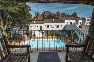 - un balcon avec deux bancs offrant une vue sur la piscine dans l'établissement Borgo Antico San Pantaleo, à San Pantaleo