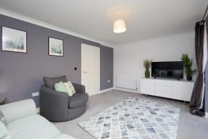 a living room with a couch and a television at Royal Derby Hospital 3 bed Town House in Derby