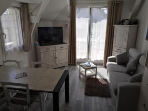uma sala de estar com um sofá e uma mesa em Appartement fonctionnel et chaleureux proche mer em Le Croisic