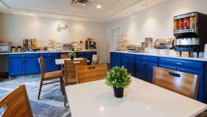 a kitchen with blue cabinets and a table and chairs at Best Western Plus Newport News in Newport News