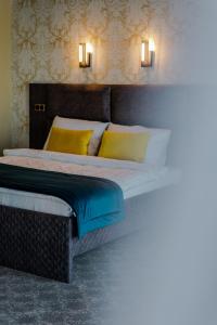 Schlafzimmer mit einem Bett mit gelben und blauen Kissen in der Unterkunft HOTEL LOBBY in Bihać