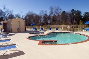 une grande piscine avec des chaises dans l'établissement Best Western Plus Newport News, à Newport News