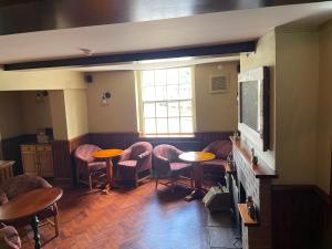 a room with tables and chairs and a window at The Swan Inn in East Ilsley