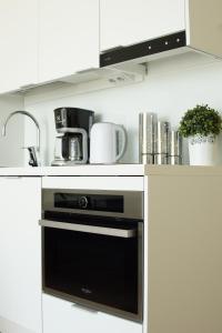 uma cozinha com um micro-ondas e um forno preto em Penthouse in the Oulu center em Oulu