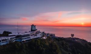 a lighthouse on top of a hill with the ocean at Litz Resort in Kvariati